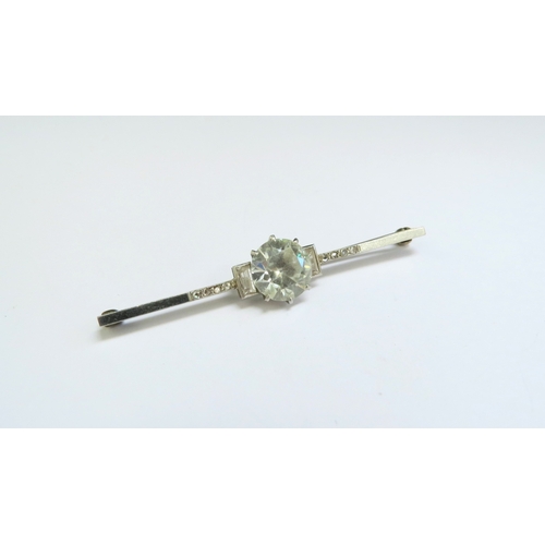 9090 - A bar brooch with large clear stone centre flanked by clear baguettes and flanked by diamonds, unmar... 