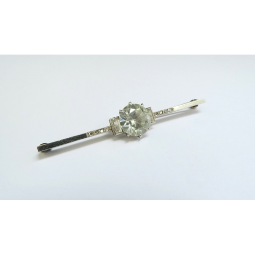 9090 - A bar brooch with large clear stone centre flanked by clear baguettes and flanked by diamonds, unmar... 