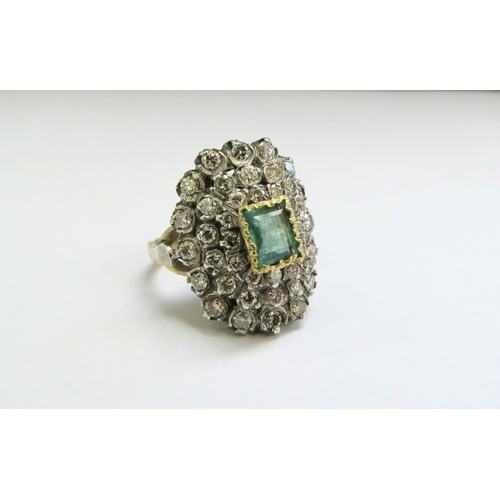 9140 - An emerald and diamond cluster ring, the central emerald 5mm x 8mm framed by diamonds 2ct approx tot... 