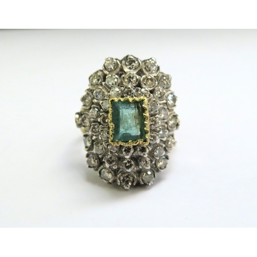 9140 - An emerald and diamond cluster ring, the central emerald 5mm x 8mm framed by diamonds 2ct approx tot... 