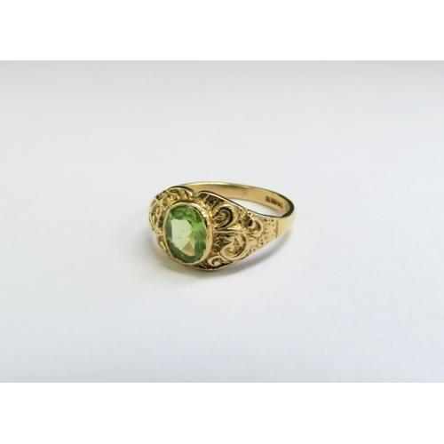 9073 - A 9ct gold ring set with an oval peridot in ornate scroll mount. Size I, 1.9g