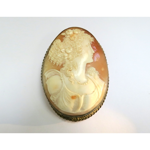 9081 - A large finely carved shell cameo brooch depicting young woman with ringlets, wearing flowers in her... 