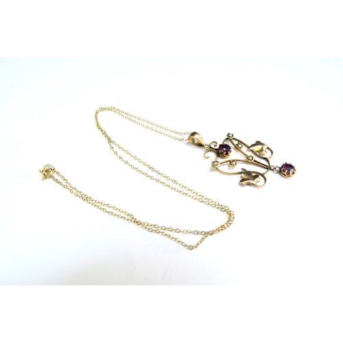 9066 - A gold chain stamped 9kt, 40cm long hung with a gold pendant with seed pearl and amethyst coloured s... 