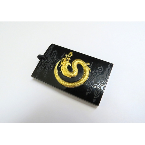 9044 - A black jade pendant of rectangular form, inset with 999.9 gold dragon, 4.5cm x 2.8cm