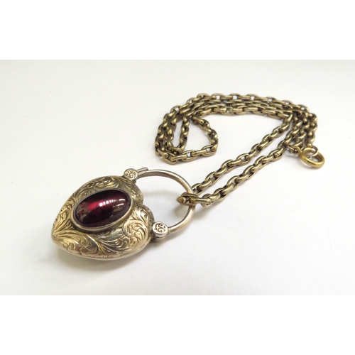 9091 - A Victorian heart shaped pendant with garnet cabochon, glass panel back, hung on chain, unmarked