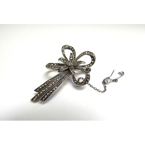 9093 - A star and bow form marcasite brooch with safety chain