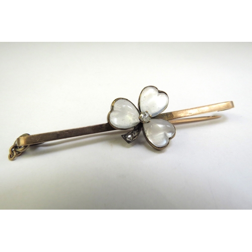 9110 - A gold bar brooch with a moonstone heart shaped clover, with central old cut diamonds with diamond s... 