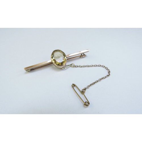 9125 - An unmarked gold bar brooch with an oval citrine, 5cm long, 4.5g  (R)  £75