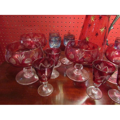 4025 - A cranberry glass claret jug with etched star decoration together with six cranberry sundae glasses,... 