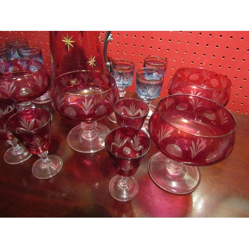 4025 - A cranberry glass claret jug with etched star decoration together with six cranberry sundae glasses,... 