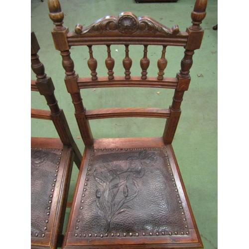 4101 - A set of six oak dining chairs with carved finial backs, leather foliate design insert seats, one se... 