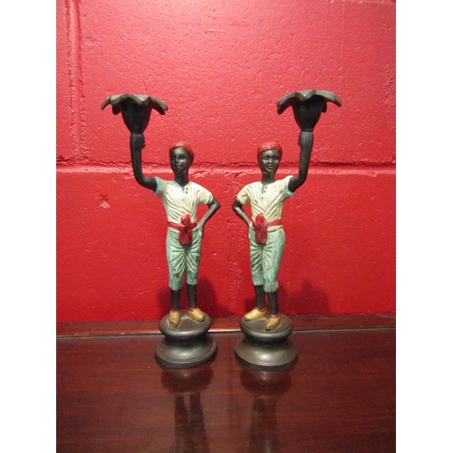 4125 - A pair of Blackamoor style cast brass candlesticks, 27cm high