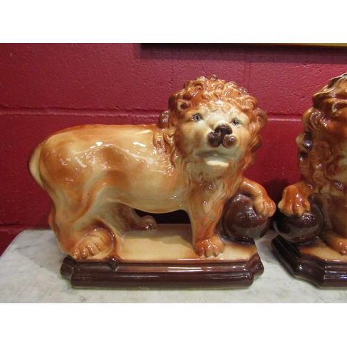 4155 - A pair of Staffordshire standing lion figures, one missing eye, 33cm long x 29cm tall