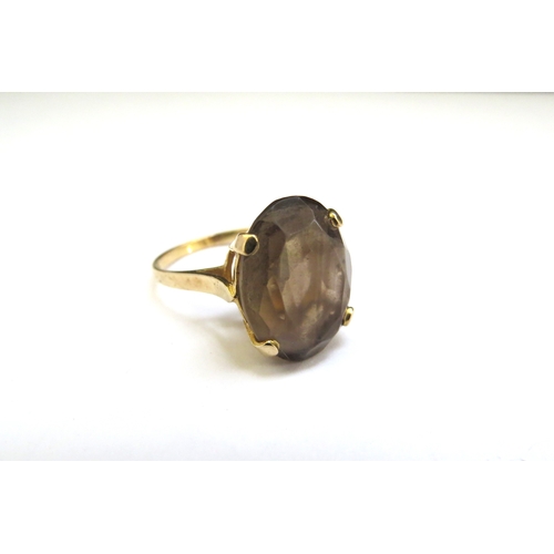 9131 - A 9ct gold ring set with an oval smoky quartz. Size N, 3.7g