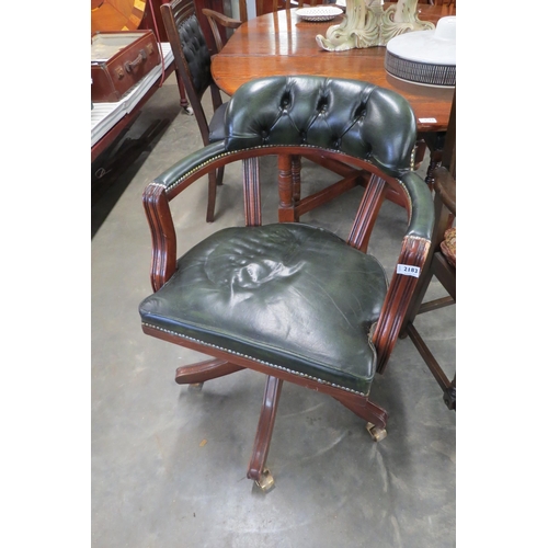 2183 - A green leather button back captains chair on brass castors