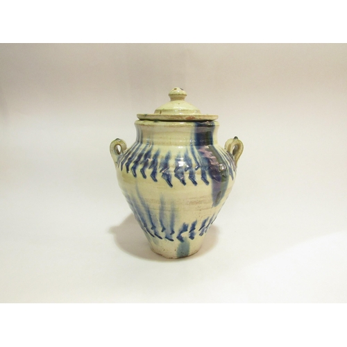 4264 - A French pottery jar with twin handles and lid dribble glaze, 26cm tall