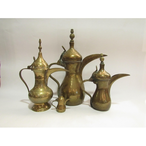 4279 - Four Eastern brass coffee pots, believed Saudi Arabian, tallest 35.5cm high