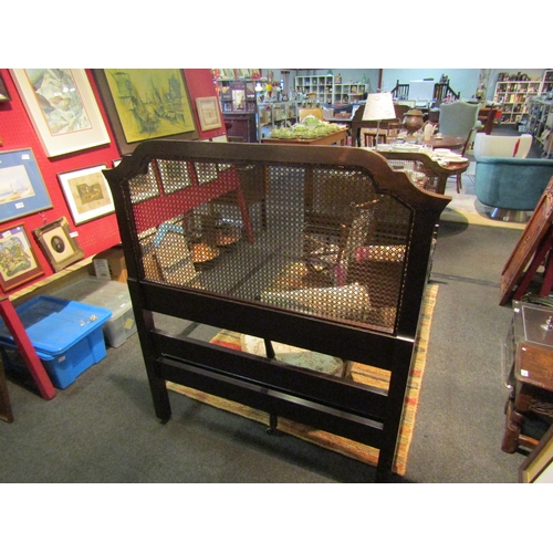 1104 - An Edwardian walnut bergere bed frame on brass castors with bobbin turned stretcher and side rails