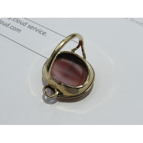 9038 - A gold ring with an oval cabochon cornelian in a snake surround, stamped 9ct. Size Q/R, 2.5cm x 2cm,... 