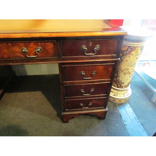 1008 - A reproduction mahogany twin pedestal desk on bracket feet, eight drawers, gilt tooled leather inser... 