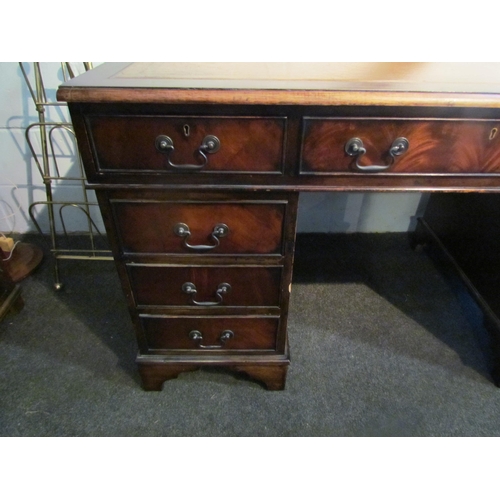 1008 - A reproduction mahogany twin pedestal desk on bracket feet, eight drawers, gilt tooled leather inser... 