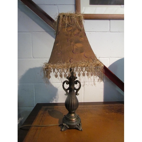 1020 - A bronzed metal table lamp with tasselled shade      (R) £0