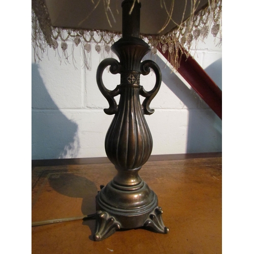 1020 - A bronzed metal table lamp with tasselled shade      (R) £0