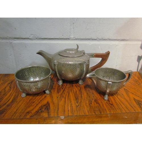 1047 - A Trafalgar Arts & Crafts pewter three piece tea set