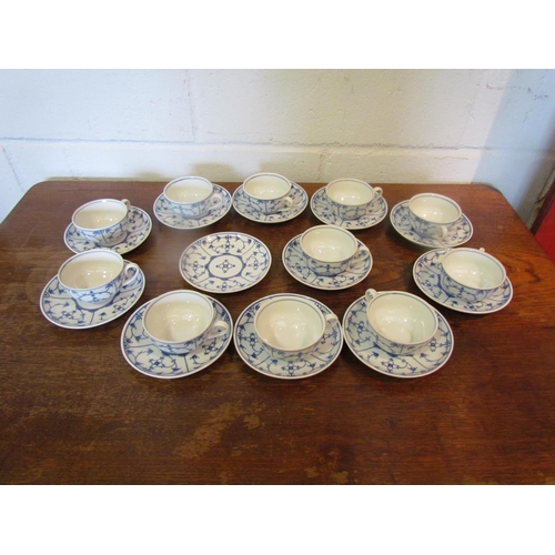 1087 - A set of blue and white German coffee cups and saucers in the onion pattern style, 11 cups and 12 sa... 