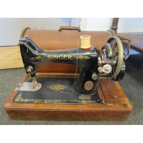 1090 - A Singer sewing machine in oak case with key