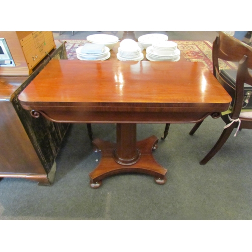 1129 - A Victorian mahogany tea table, the fold-over top over a scrolled frieze, to a faceted column, on qu... 