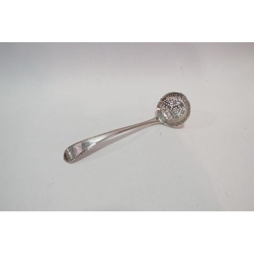 1279 - A Georgian silver sifter spoon with feather edge decoration and engraved crest.  Lion passant and ma... 