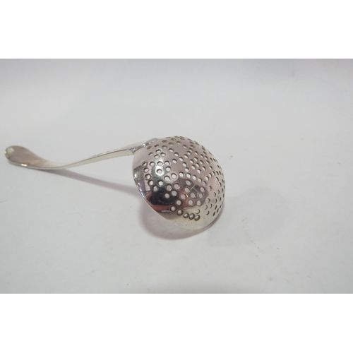 1279 - A Georgian silver sifter spoon with feather edge decoration and engraved crest.  Lion passant and ma... 