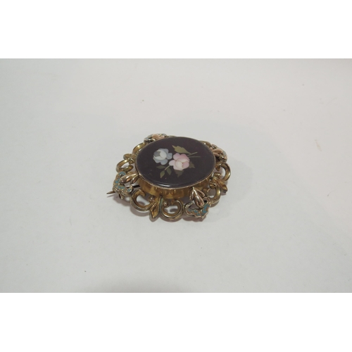 1299 - A Pietra Dura oval brooch in ornate frame with blue enamel detail, glass panel back  (C)