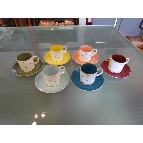 1444 - A set of six Susie Cooper coffee cans and saucers, multicoloured with gilt star design