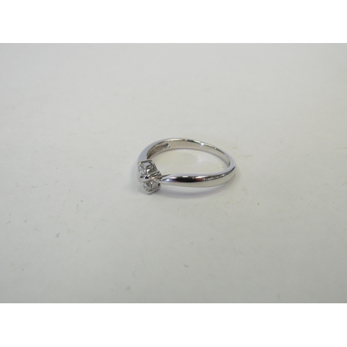 1255 - A 9ct white gold ring with two small diamonds in a crossover setting. Size O, 2.4g   (C)