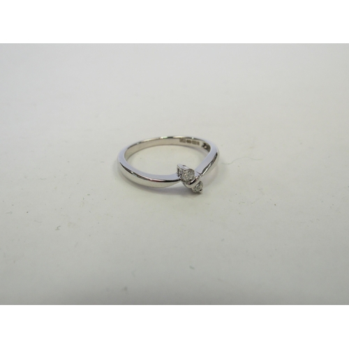 1255 - A 9ct white gold ring with two small diamonds in a crossover setting. Size O, 2.4g   (C)