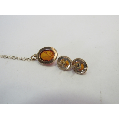 1317 - A pair of 9ct gold amber earrings and a matching pendant on chain stamped 9k  (C)