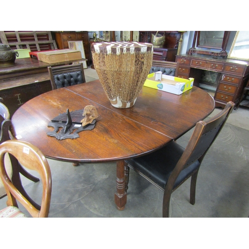 2180 - An oak circular dining table with extension leaf