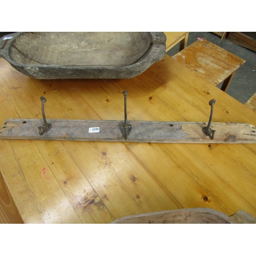 2290 - A 19th Century pine coat rack with three iron hooks, 96cm long.