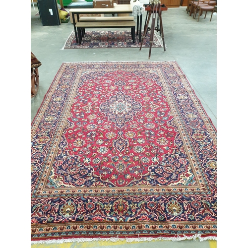 2315 - A multicoloured wool fringed carpet, maroon ground blue borders, 350m 245cms