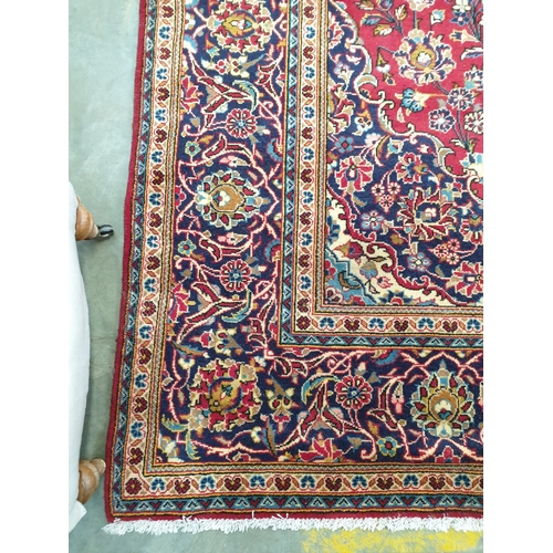 2315 - A multicoloured wool fringed carpet, maroon ground blue borders, 350m 245cms