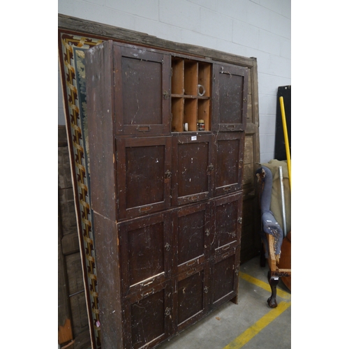 2300 - An Edwardian stained pine cupboard with pigeon hole interiors,one door missing, in two sections, bar... 