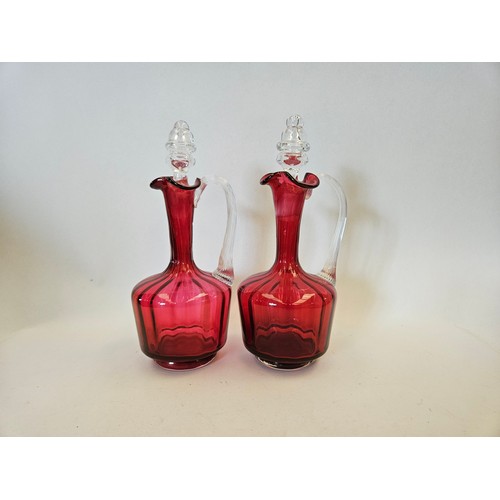 1160 - A pair of Victorian and later cranberry glass decanters