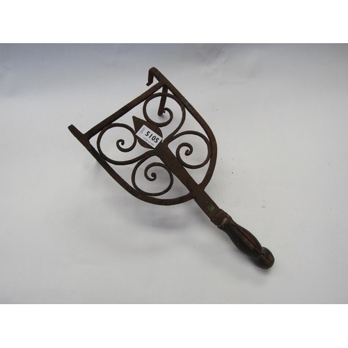 5105 - A decorative iron trivet, wooden handle a/f