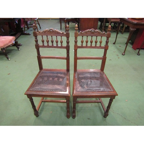 4063 - A set of six oak dining chairs with carved finial backs, leather foliate design insert seats, one se... 