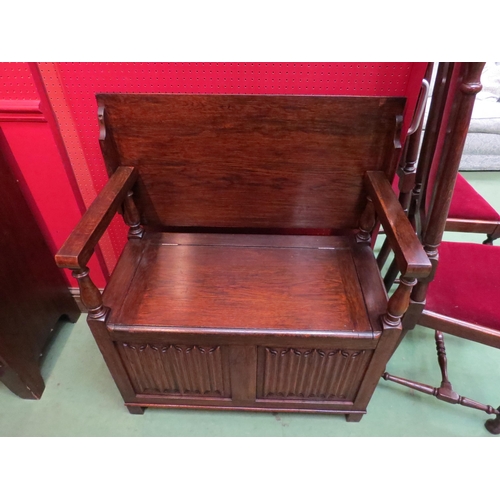 4099 - A monk's bench with table top and box seat, the hinged seat and turned supports over a carved linen-... 