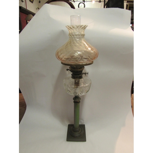 4144 - A Victorian oil lamp, the peach tinted shade over a clear cut glass reservoir, to a reeded column, s... 