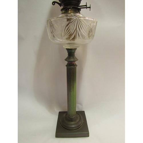 4144 - A Victorian oil lamp, the peach tinted shade over a clear cut glass reservoir, to a reeded column, s... 