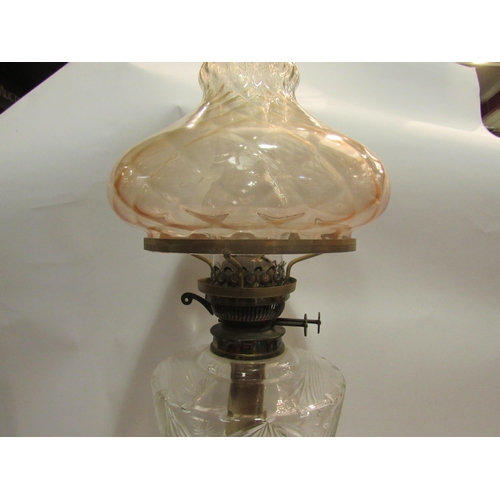 4144 - A Victorian oil lamp, the peach tinted shade over a clear cut glass reservoir, to a reeded column, s... 